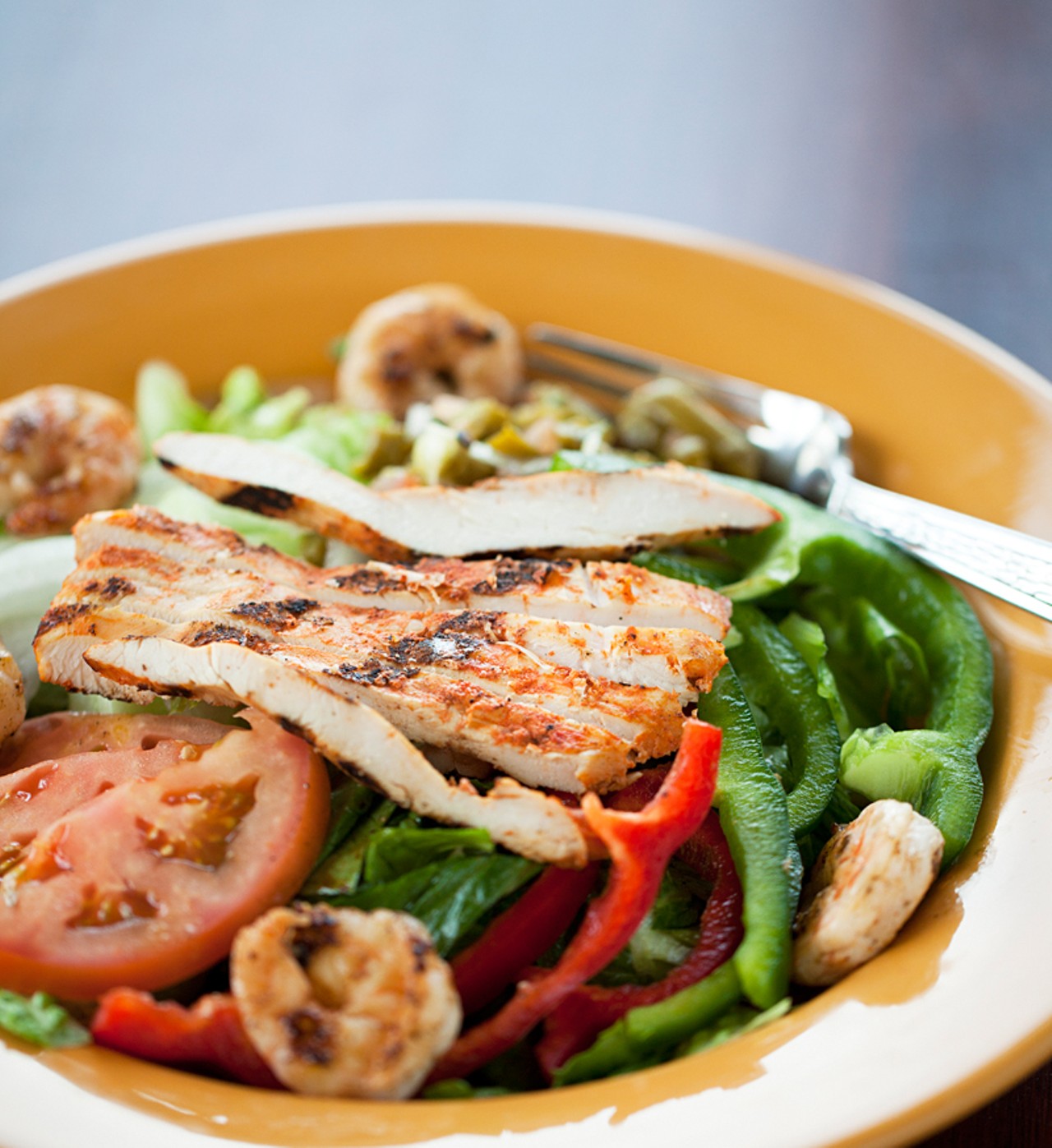 Azteca Salad" is grilled chicken and shrimp on a bed of romaine lettuce with nopales, red bell pepper, green bell pepper and onions, and it's served with the house chipotle-ranch dressing.