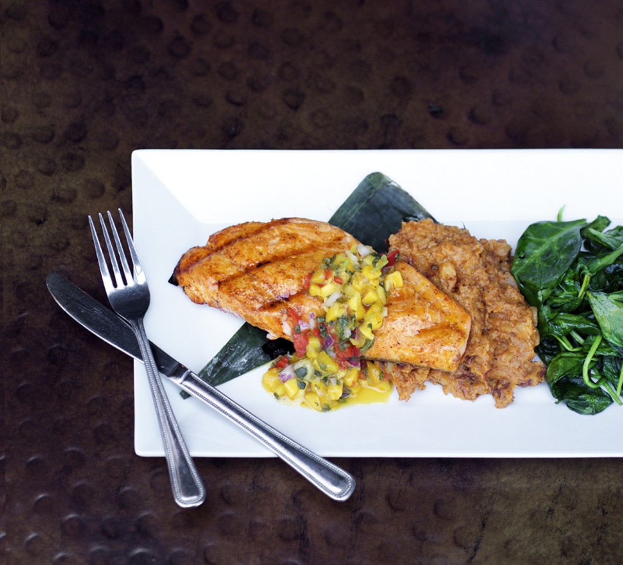 The SALM&Oacute;N YUCATECO is Atlantic salmon marinated in achiote and grilled in a banana leaf. Topped with mango salsa and annatto oil, it's served with chile mashed potatoes and garlic spinach.