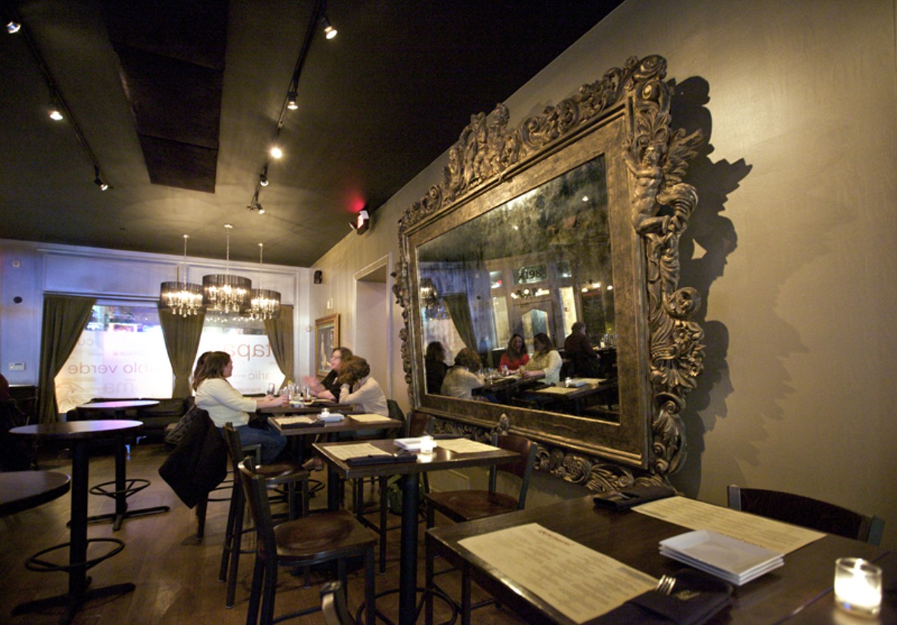 The large gilded mirror that adorns the wall opposite the bar.