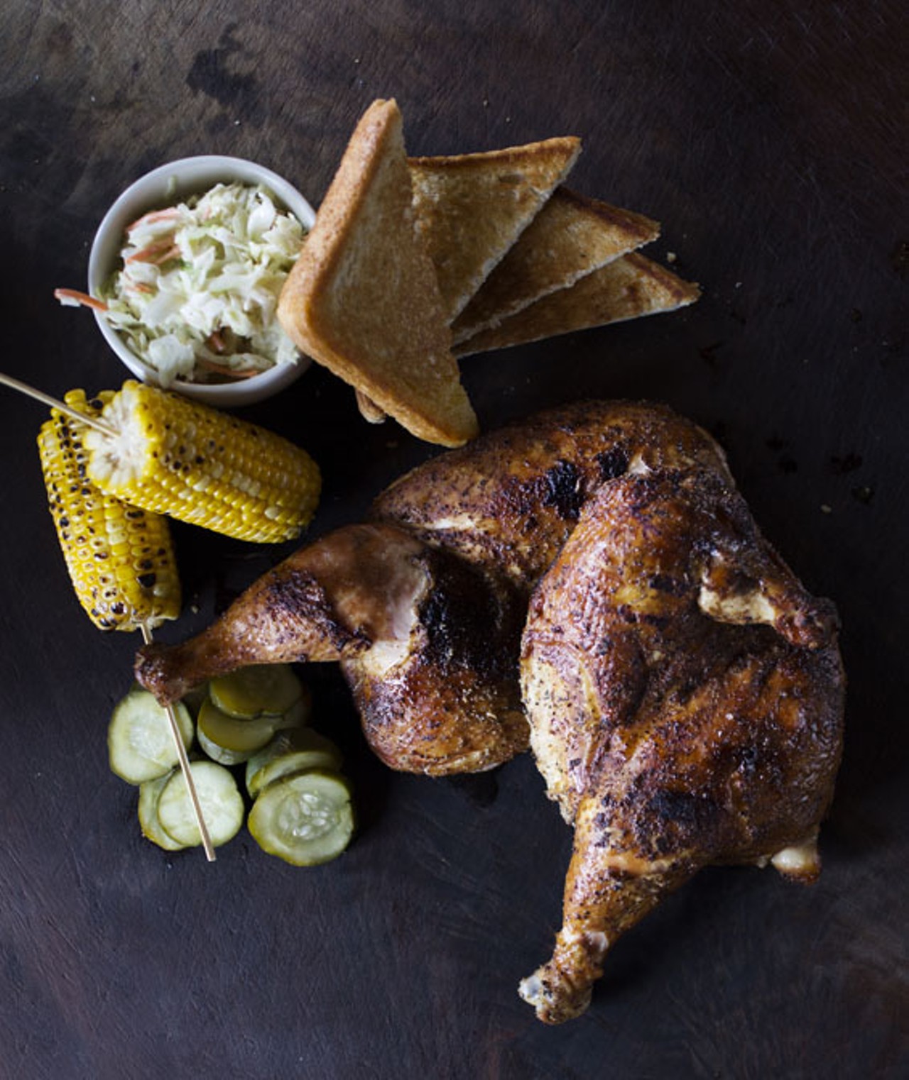 Half chickens with corn on the cob and slaw.